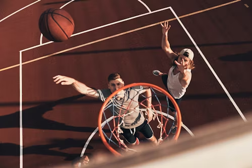 Basketball player jumping high toward the rim attempting a dunk